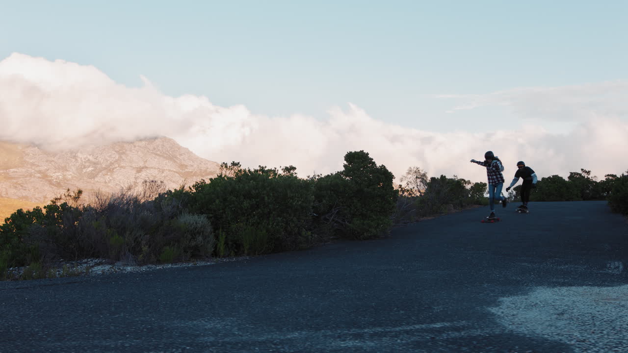 felices amigos multiétnicos longboarding juntos navegando cuesta abajo en una hermosa carretera de campo divirtiéndose patinando pasando el rato disfrutando de unas vacaciones de verano relajadas en cámara lenta