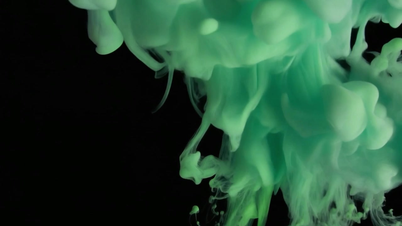 Inchiostro verde che cade e si mescola nell'acqua