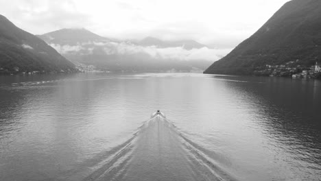 schwarz-weiß-slow-motion-aufnahme eines bootes, das von oben über die gewässer des lake como gleitet