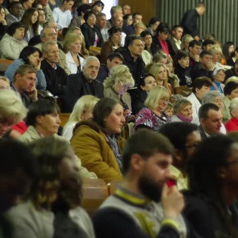 crowd of people to sitting and listening in a large hall
