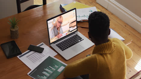 african american female teacher using laptop on video call with female student