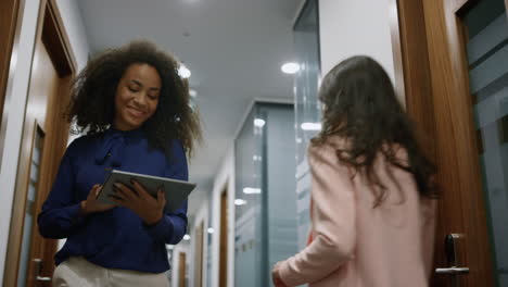 Woman-ceo-searching-tablet-walking-office-meeting-collegue-in-business-room.