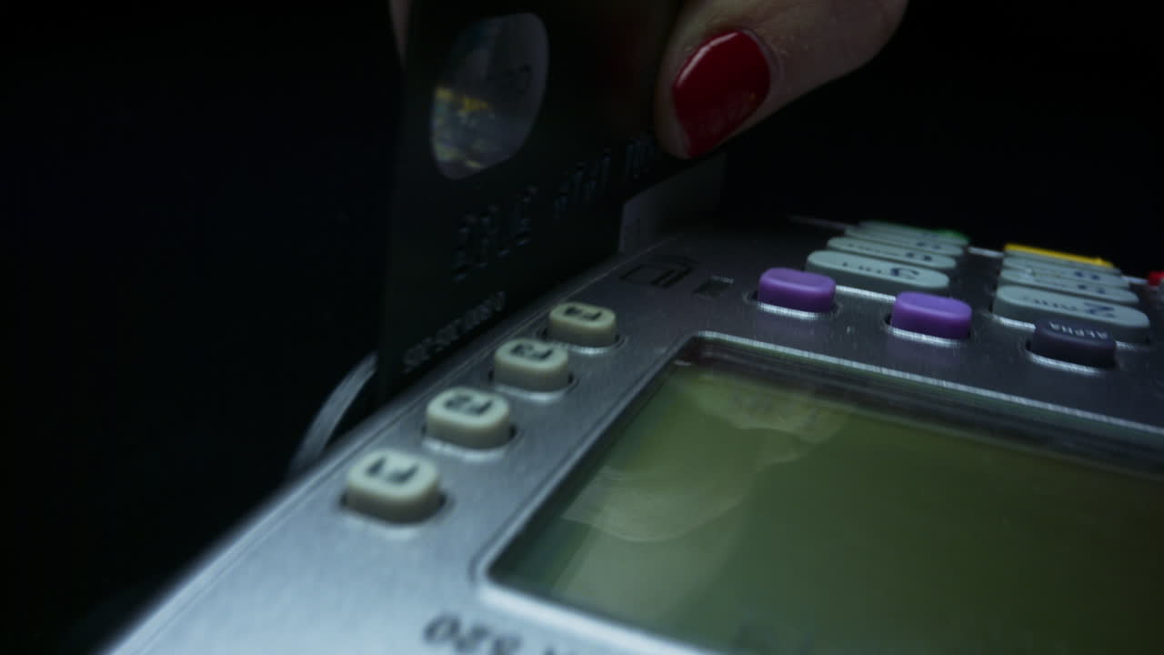 Woman swiping credit card through terminal. Woman paying with card in terminal