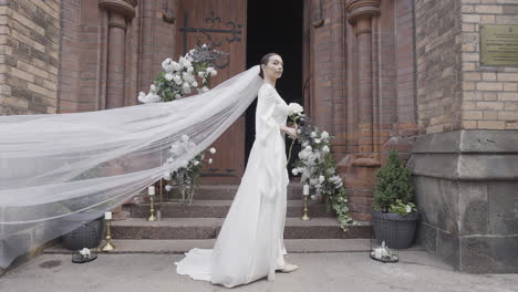 novia en un vestido blanco con velo en una iglesia