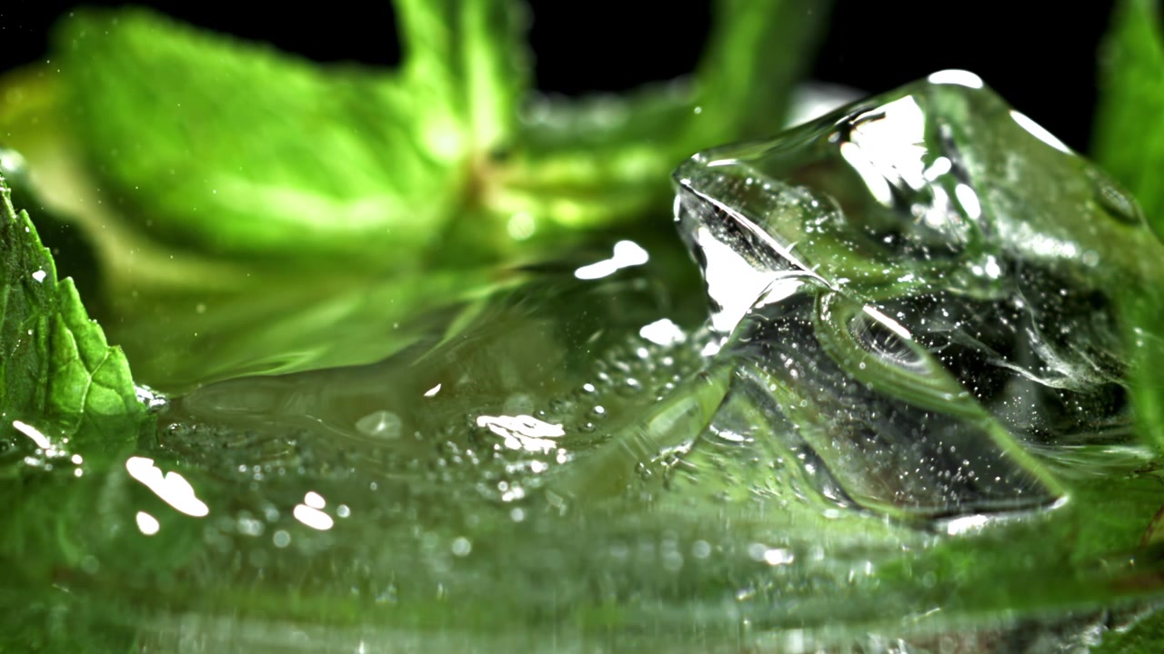 Primo piano macro di cubetti di ghiaccio e menta rinfrescanti nell'acqua
