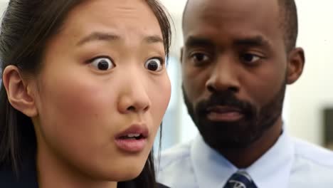a woman expresses surprise and concern during a significant conversation with a man in an office setting. the interaction is filled with tension and curiosity among coworkers nearby.