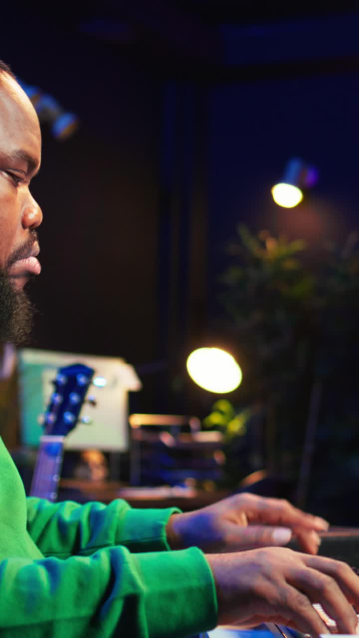 Uomo afroamericano che suona la tastiera in uno studio musicale