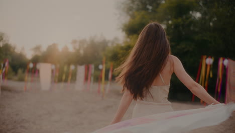 cheerful female brunette swaying sarong at beach