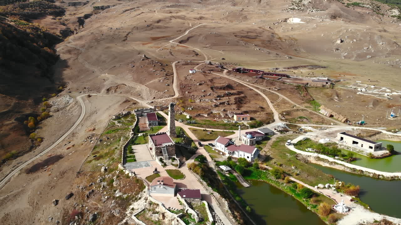 Aerial view of a mountain landscape with a castle and ponds