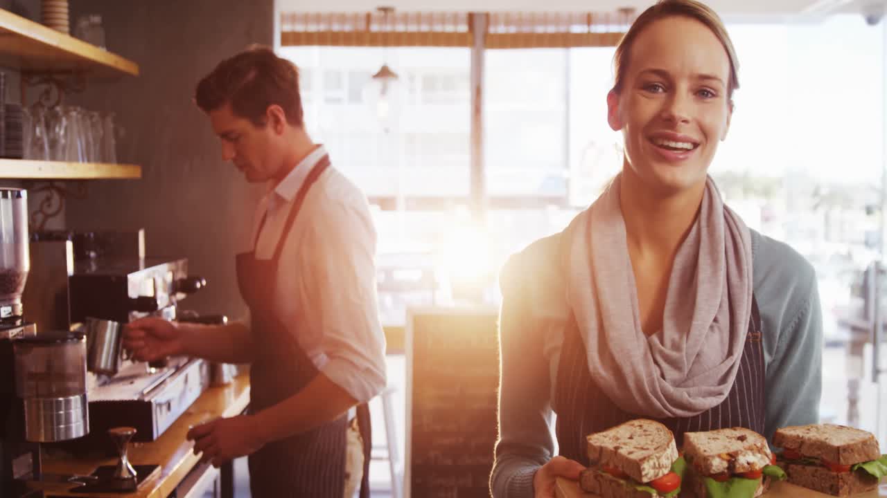 Waitress holding a tray with sandwiches in caf&Atilde;&copy;