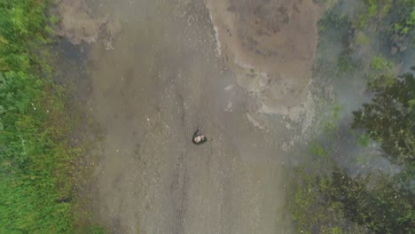 vista aérea de una mujer madura de pie cerca de un lago 4k