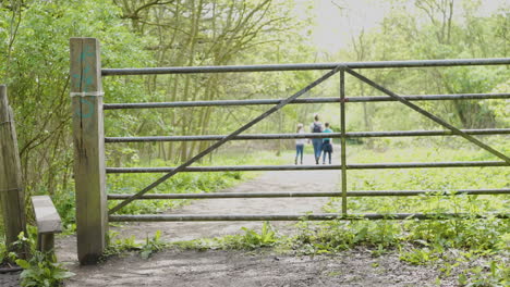 family walking through a gate in the woods