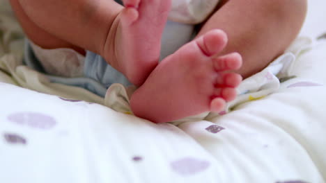 a baby's tiny feet are kicking and stretching as it is lying on its crib inside the nursery