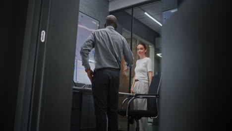 happy stock trader looking at real-time stocks on computer, talking on phone, celebrating winning trade deal with colleague. excited african american investment agent making profitable investments.