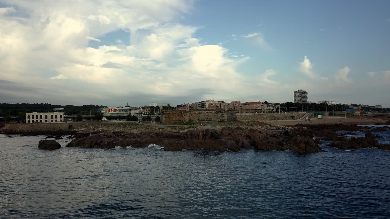 Vista aérea de uma fortaleza histórica na costa atlântica do Porto, Portugal. Litoral rochoso, ondas calmas do oceano e paisagem urbana costeira pitoresca com atmosfera relaxada de verão