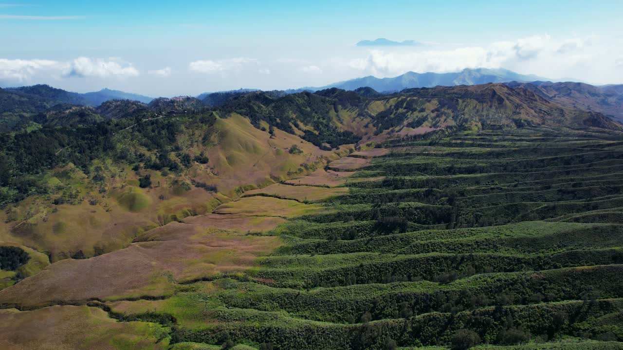 Aerial view of a mountain landscape with hills, valleys, and trees