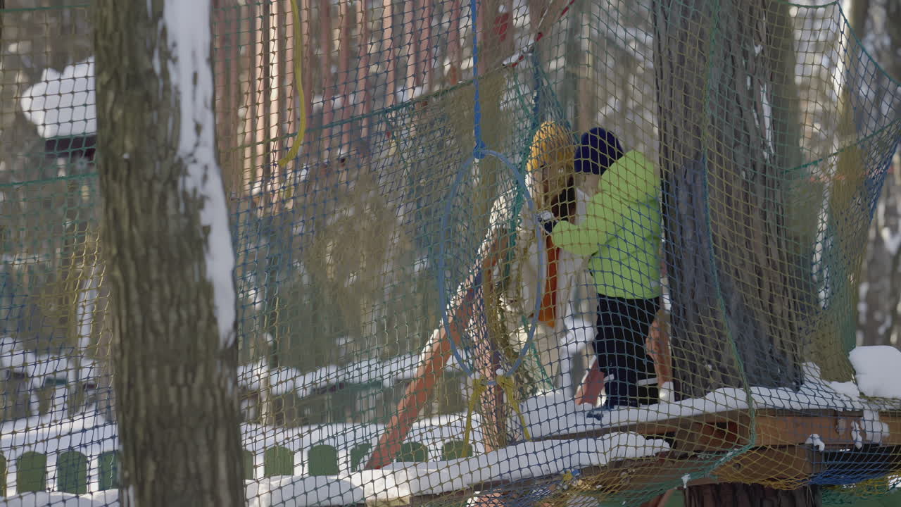 ребенок поднимается на зимнюю игровую площадку