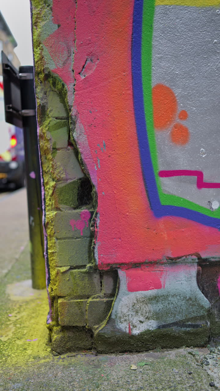 el vídeo vertical de primer plano detalla el colorido spray de graffiti pintado en la pared en la calle de la ciudad de londres, reino unido.
