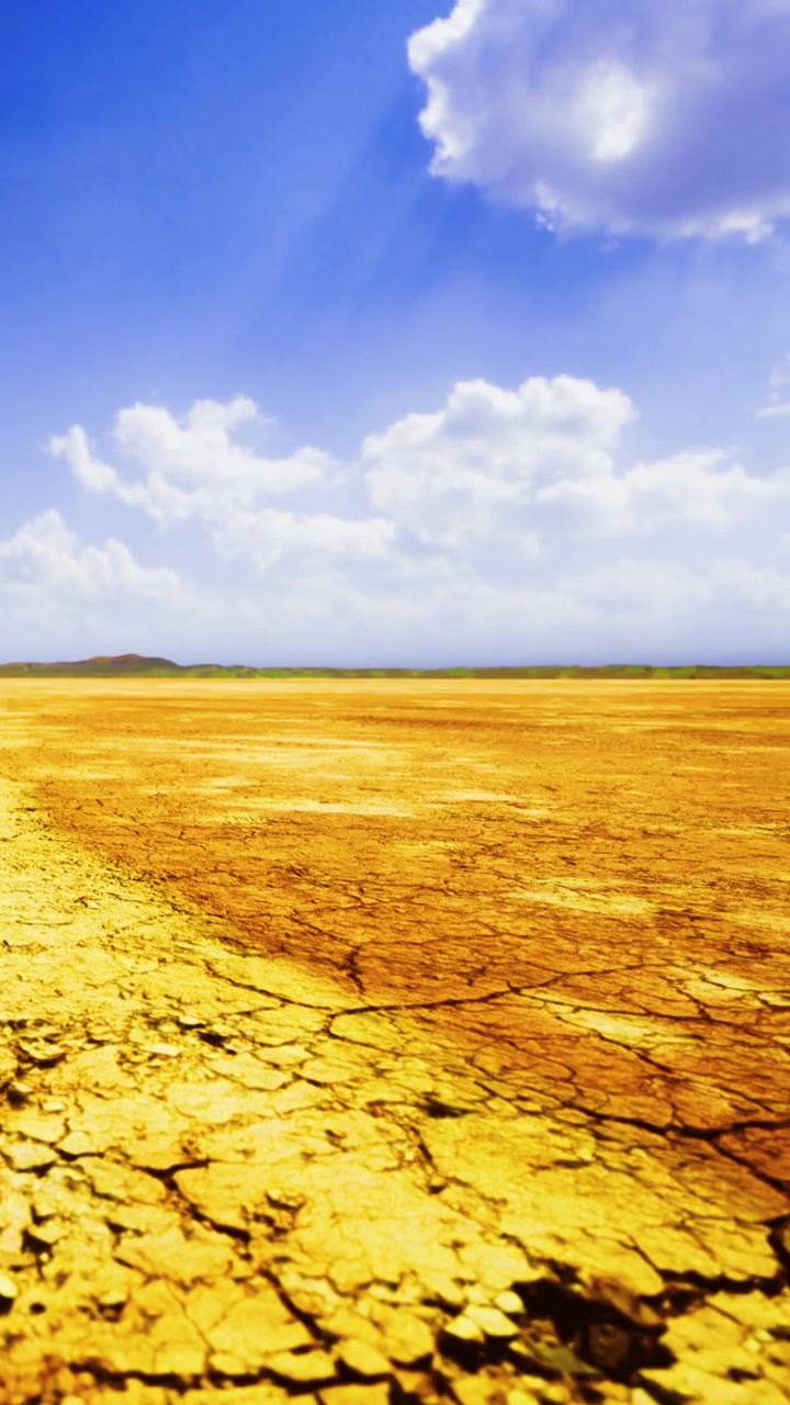 Dry land stretches out under blue skies with white clouds above