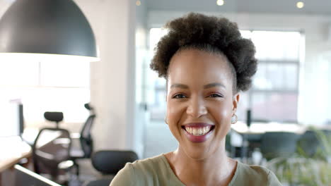 a young african american woman smiles brightly in a business office setting