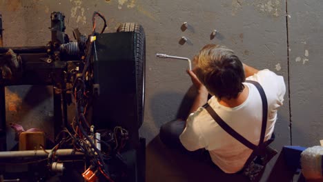 mecánico masculino quitando el neumático del coche con la llave de la llanta 4k