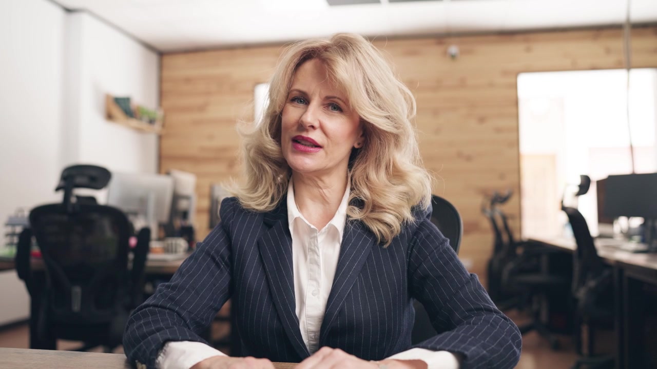 Donna d'affari matura e professionale che parla durante una videoconferenza in ufficio
