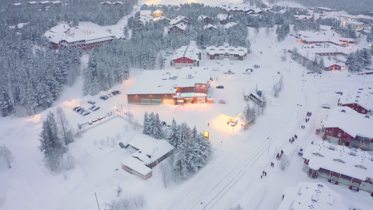 드론 공중 기울기, 레비, 도로 스키 마을에 버스와 보행자가 있는 핀란드