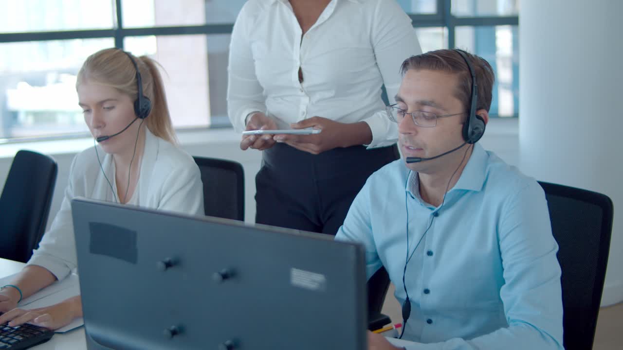 사무실에서 콜센터 운영자를 돕는 젊은 아프리카계 미국인 매니저