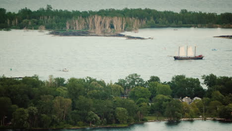 an old sailing ship sailing among the islands in cloudy weather