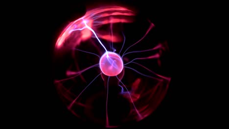 a female hand touches a plasma ball giving out small lightning bolts. experiments with electricity in the dark.