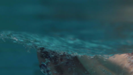 underwater shot of bearded man swimming with freestyle technique