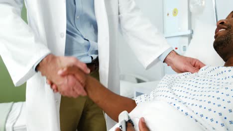 el médico estrechando la mano del paciente.