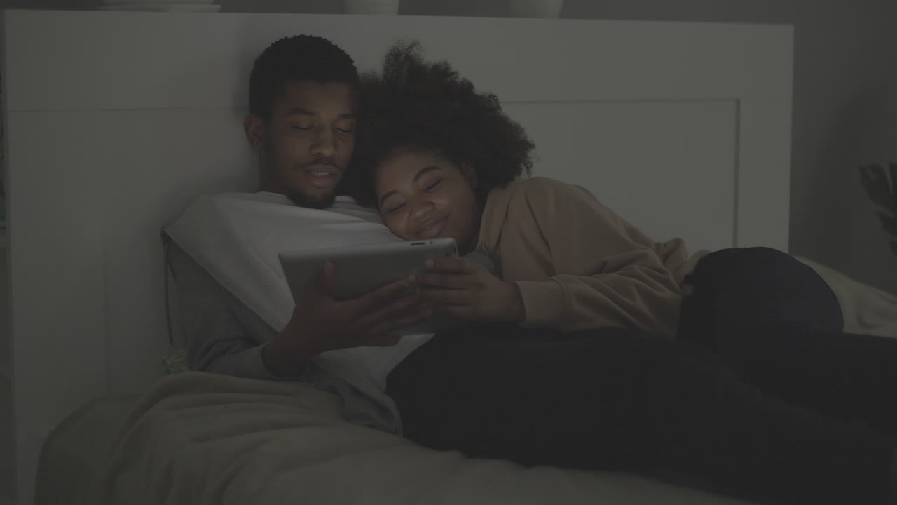 Young african american couple watching a movie on the tablet