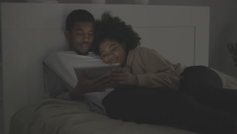 young african american couple watching a movie on the tablet