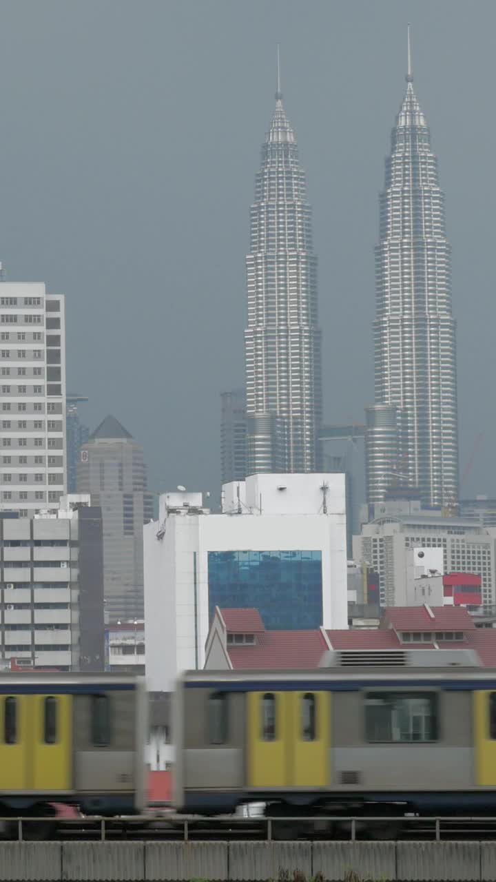 Tren pasando por el paisaje urbano de Kuala Lumpur con las Torres Gemelas Petronas