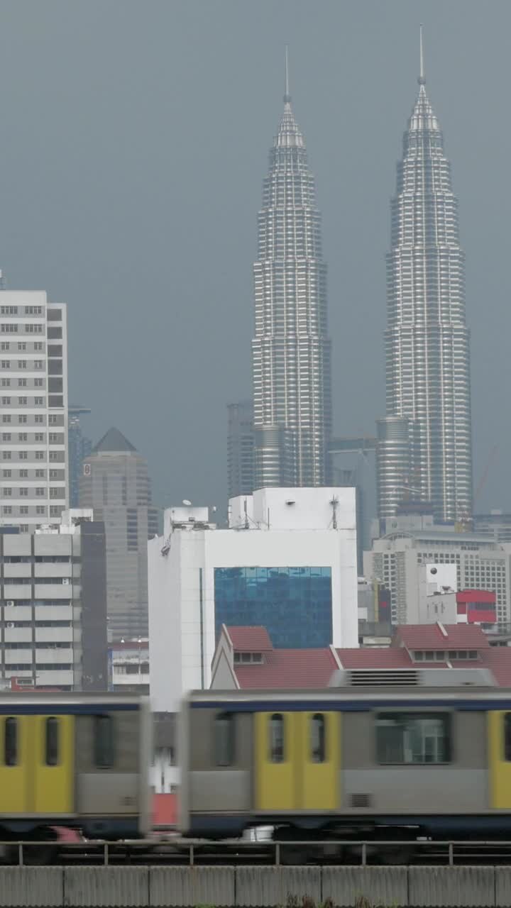 Treno che attraversa il paesaggio urbano di Kuala Lumpur con le Torri Gemelle Petronas.