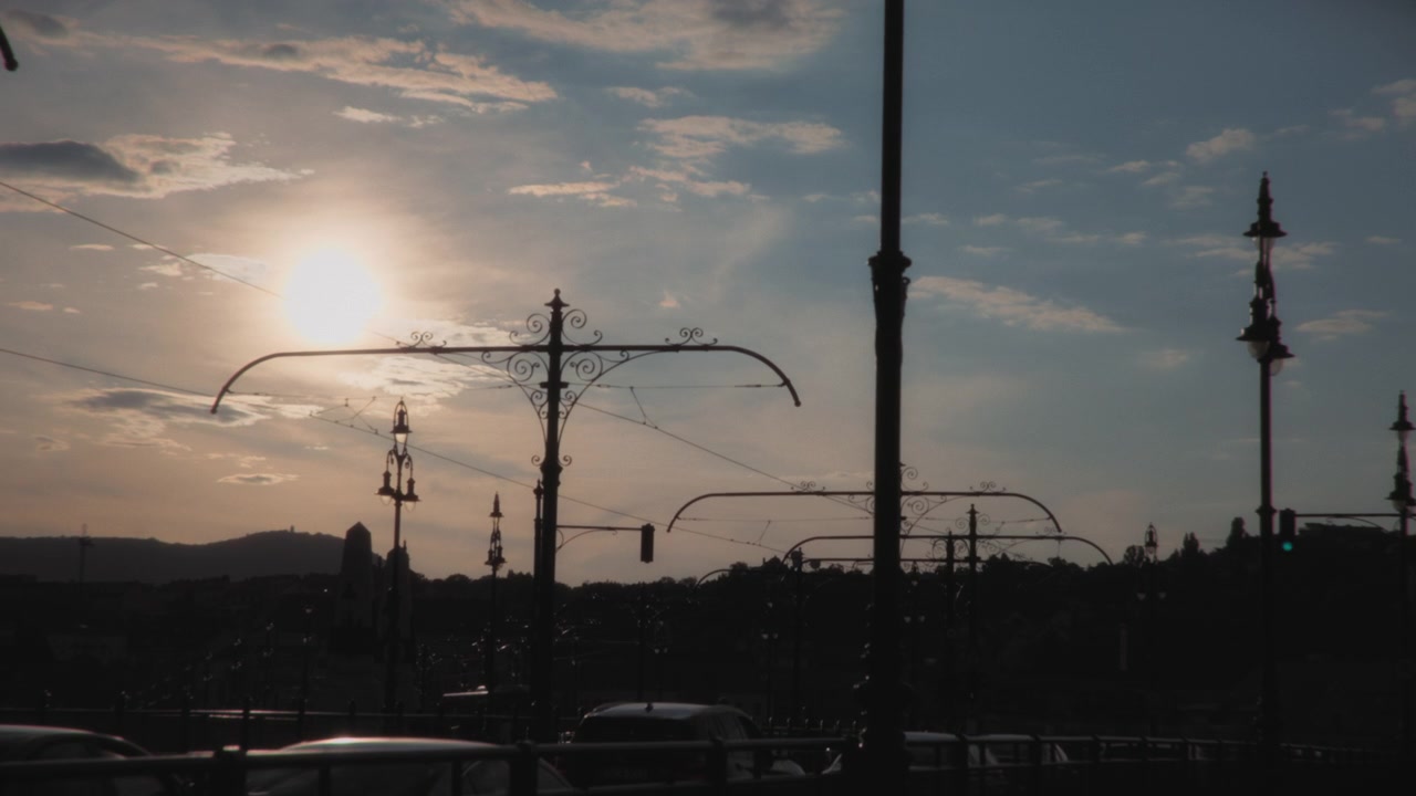 Silhouetted Street Lamps Against a Sunset Sky in the City