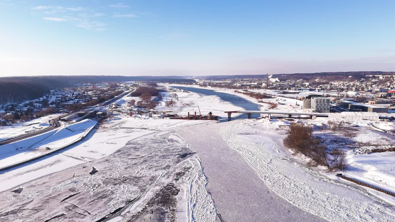 Sillan rakennustyömaa ja jäätynyt joki, panoraamailmakuva.
