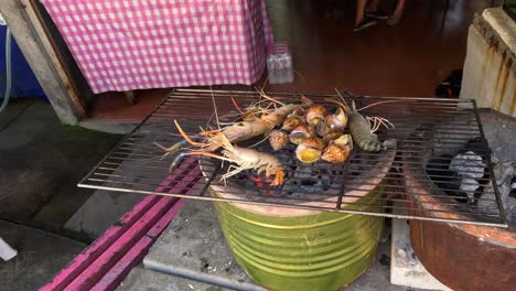 seafood cooking over charcoal on a metal grill.