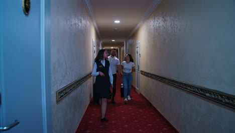 couple going into hotel room. happy couple with baggage walking at hotel hallway
