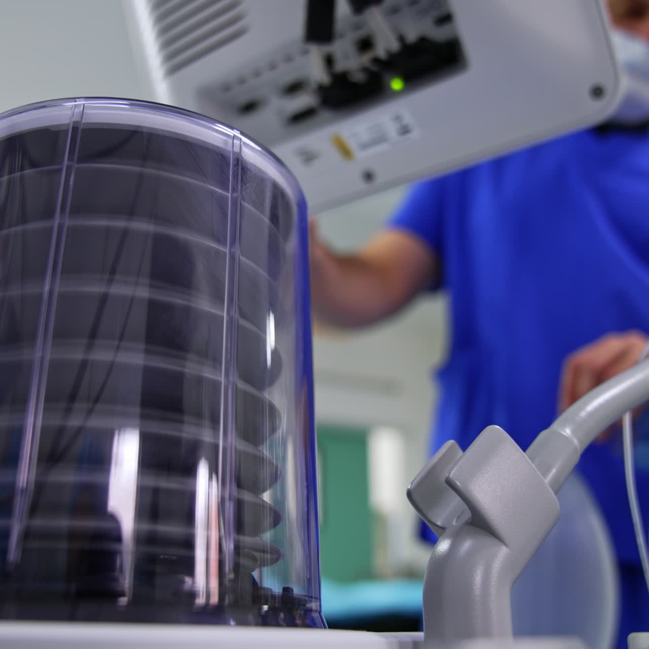A pump of a lung ventilator machine starting to move. Doctor choosing parameters on the screen of equipment. Low angle view. Blurred backdrop