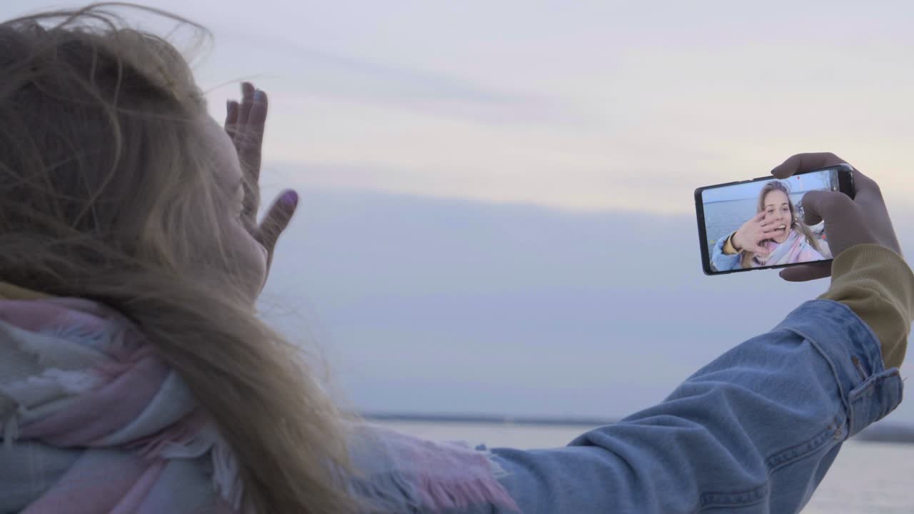 chica habla en teléfono inteligente por llamada de video en viajes