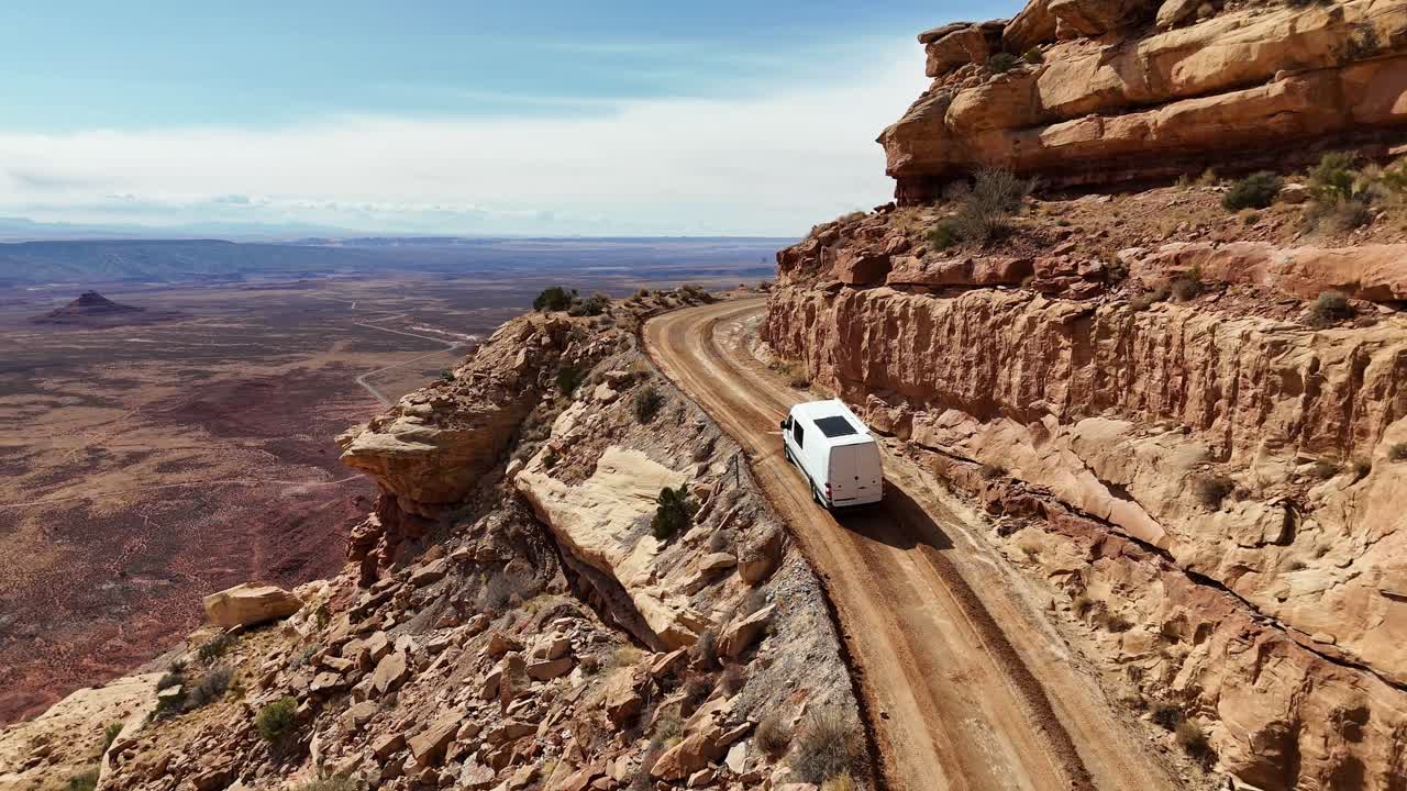 Camper Van Driving on the edge of a cliff going up a mountain, The Moki Dugway near Mexican Hat, Utah, Drone View
