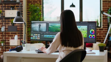 asian woman uses advanced editing software in a modern office.