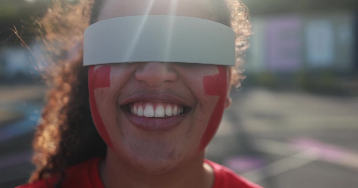 Young Person with Futuristic Visor and Red Face Paint Expressing Emotions