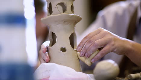 person working on clay sculpture