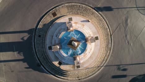 vista de pájaro giratoria aérea sobre una rotonda o isla de tráfico en medina sidonia en españa andalucía cádiz con una fuente y columnas con columnas de temática romana con tráfico en el lateral