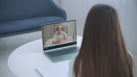 Educación-A-Distancia-En-Línea.-Una-Mujer-Estudia-En-Casa-Y-Realiza-Una-Videollamada-Con-Zoom-De-Aprendizaje-Electrónico.-Un-Aprendizaje-A-Distancia-En-Casa.-Vista-Por-Encima-Del-Hombro.