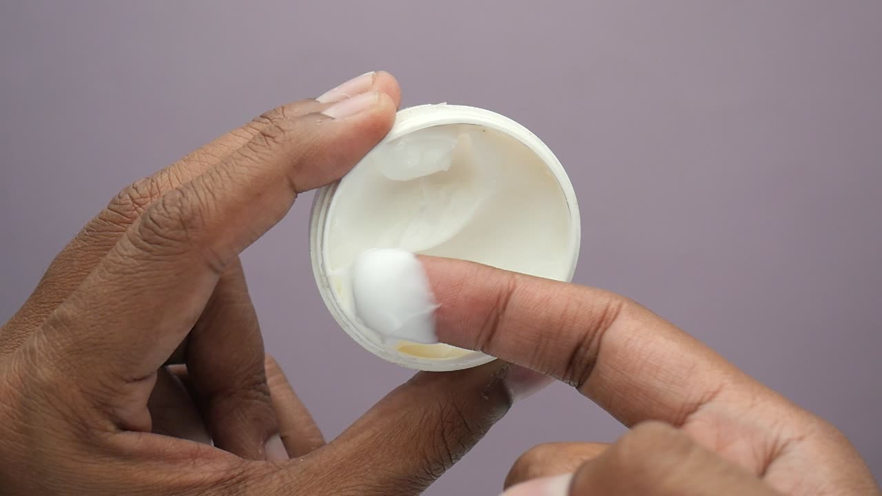 la aplicación de la crema de un frasco