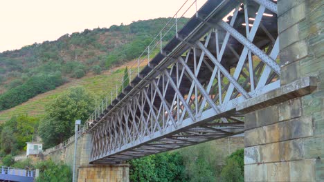 estructura de un viejo puente ferroviario de hierro con montañas en el fondo en pinhao, portugal